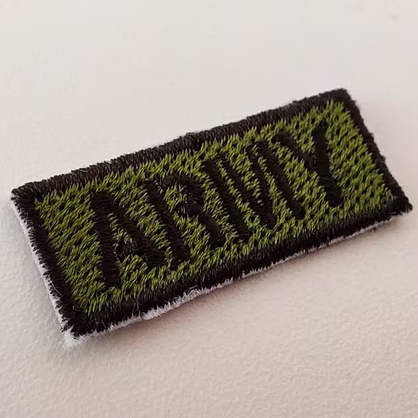 Patch tattica militare a bassa visibilità in toni verde oliva e nero per reparti operativi.